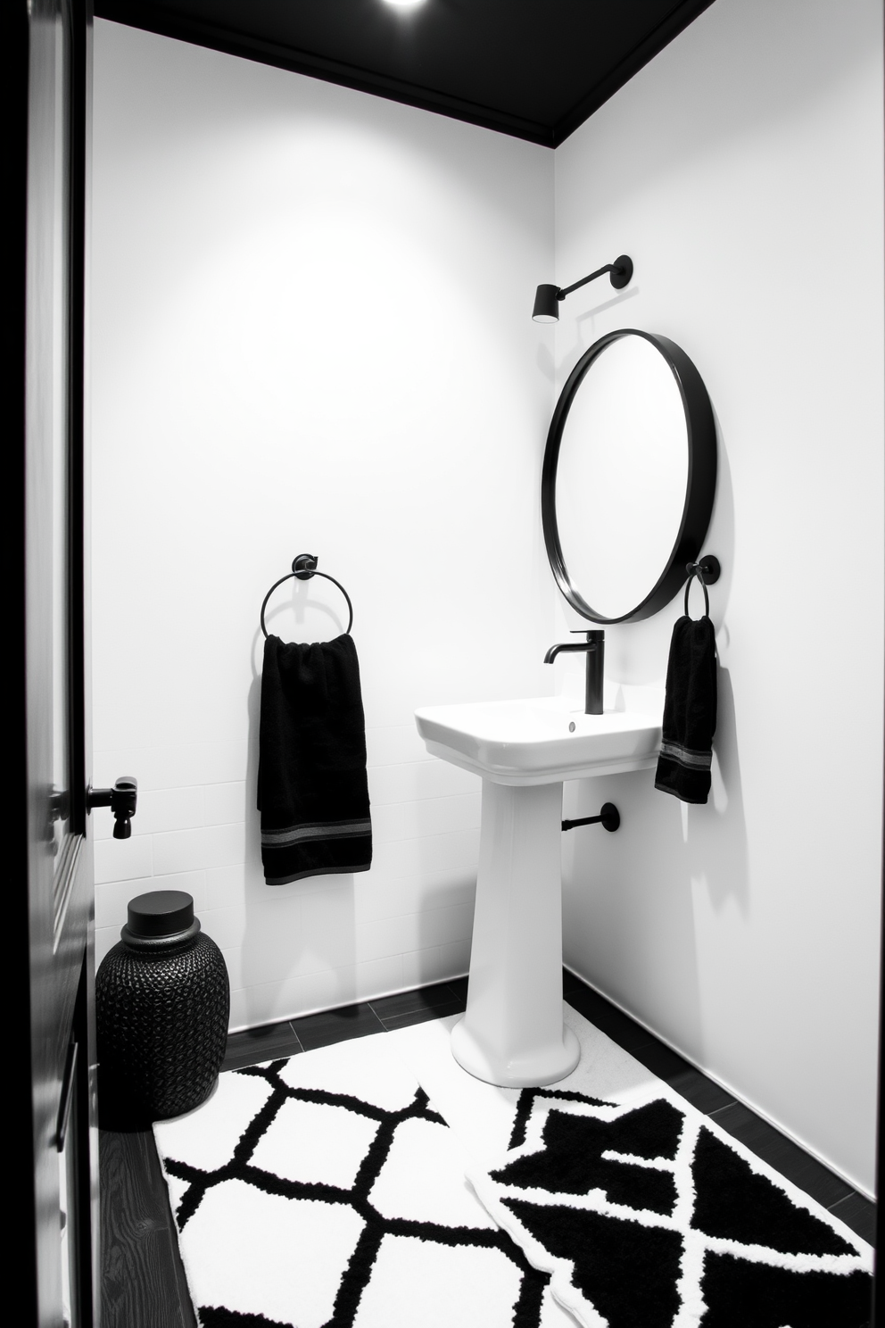 Chic black and white contrast design. The walls are painted in a crisp white, while the fixtures and accessories are in sleek black, creating a striking visual balance. The powder room features a modern pedestal sink with a black faucet and a round mirror framed in black. A geometric patterned rug in black and white lies on the floor, adding texture and interest to the space.