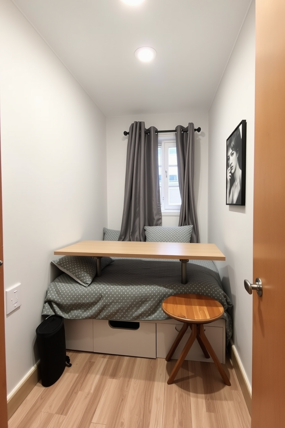 A very small bedroom features a foldable table that can be easily tucked away when not in use. The walls are painted in a light, airy color to create an illusion of spaciousness, while a cozy bed with under-bed storage maximizes functionality.