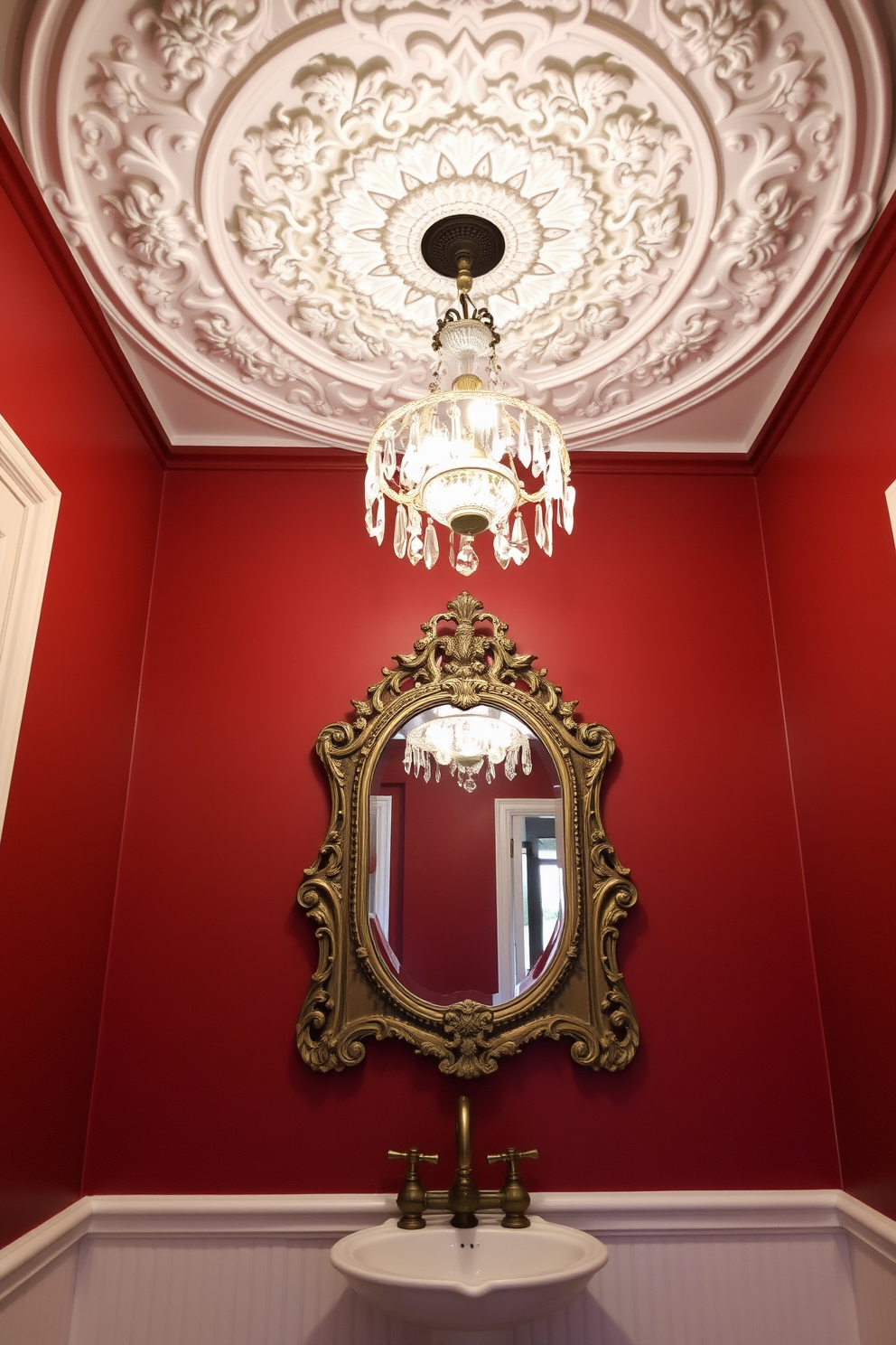 A decorative ceiling medallion is the focal point of the Victorian powder room, intricately designed with floral patterns and a soft white finish. Below it hangs an elegant chandelier adorned with crystals, casting a warm glow over the richly colored walls and ornate fixtures. The powder room features a vintage pedestal sink with intricate detailing and a polished brass faucet. Complementing the sink, a beautifully framed mirror with an antique finish hangs above, enhancing the room's classic charm.