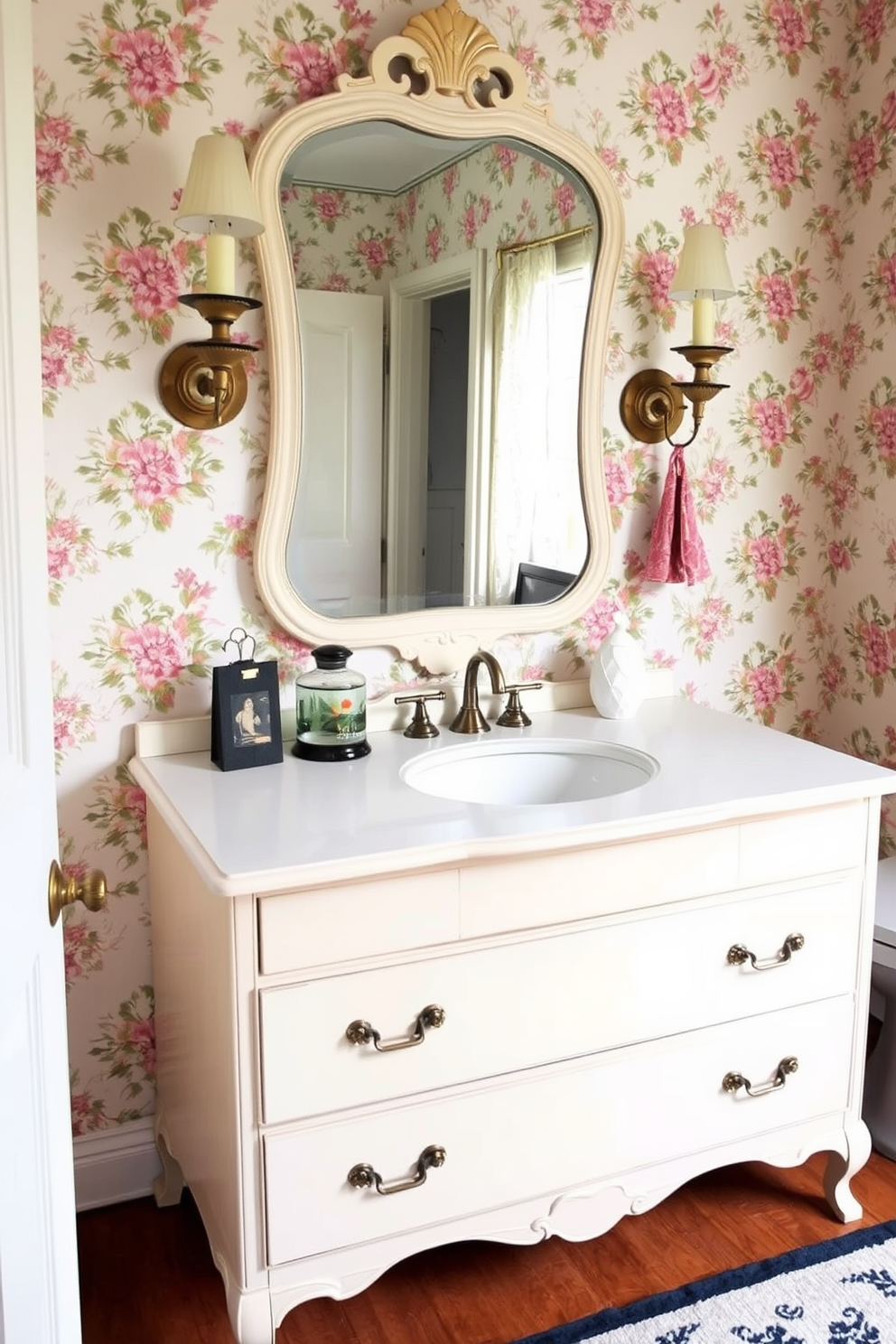 Antique mirror with ornate frame creates a focal point in the vintage powder room. The walls are adorned with floral wallpaper, and a small pedestal sink complements the classic design.