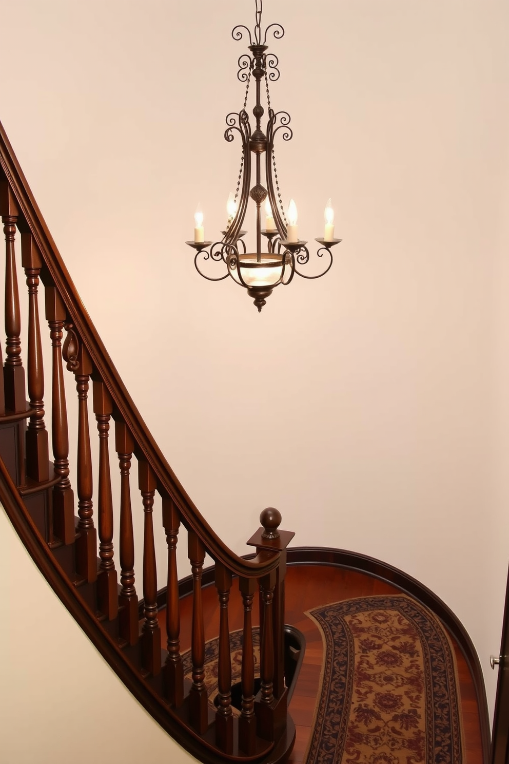 An elegant chandelier hangs gracefully above the staircase, casting a warm glow that enhances the beauty of the space. The staircase features intricate wooden balusters and a rich mahogany finish, showcasing classic craftsmanship and timeless style. The vintage staircase design incorporates a runner rug with ornate patterns, adding a touch of color and texture. Soft lighting highlights the curves of the staircase, creating an inviting atmosphere that draws you in.