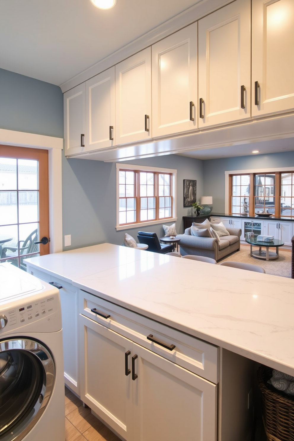 A functional laundry room features a spacious folding area with a large countertop made of quartz. The walls are painted in a soft blue tone, and ample cabinetry provides storage for laundry essentials. The walkout basement design includes large windows that allow natural light to flood the space. Cozy seating arrangements and a small kitchenette create an inviting atmosphere for entertaining.