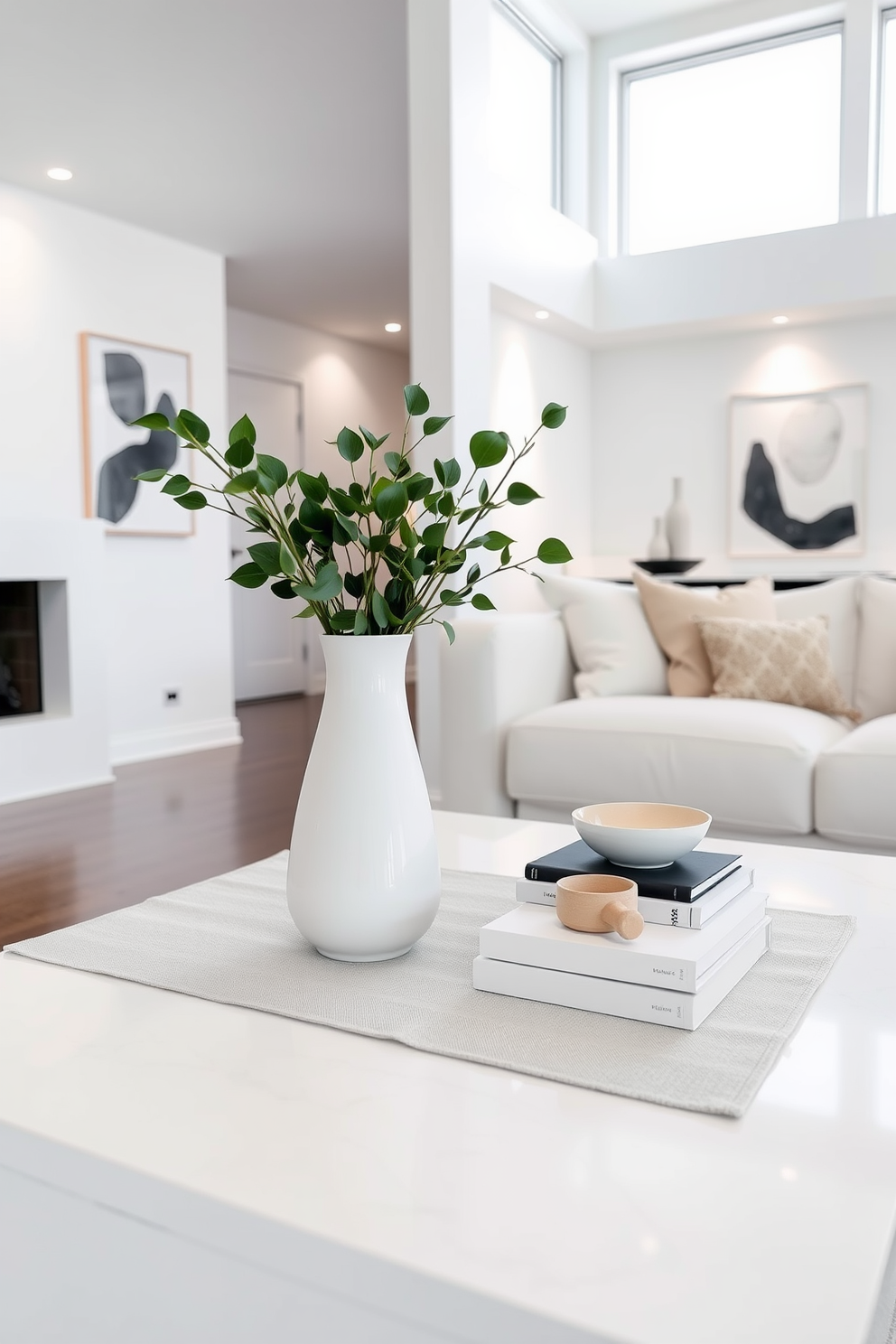 A minimalist white coffee table centerpiece featuring a sleek ceramic vase filled with fresh greenery sits atop a soft linen runner. Surrounding the vase are a few carefully selected coffee table books and a small decorative bowl for added texture. The white basement design incorporates clean lines and an open layout, with a cozy seating area that includes a plush sectional sofa. Large windows allow natural light to flood the space, while subtle accent lighting highlights the modern artwork on the walls.