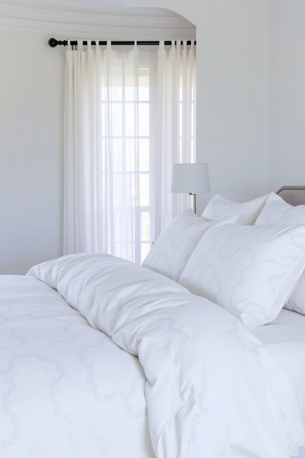 A serene bedroom setting with white bed linens featuring subtle patterns that add texture without overwhelming the space. The walls are painted in a soft pastel hue, and natural light filters through sheer curtains, creating a tranquil atmosphere.