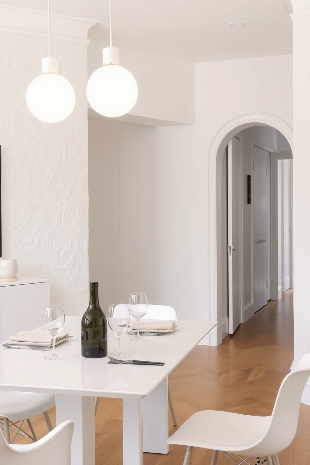 Chic white pendant lights hang gracefully above a sleek dining table set for an elegant meal. The white dining room features soft textured walls and a polished wooden floor, creating a serene ambiance.