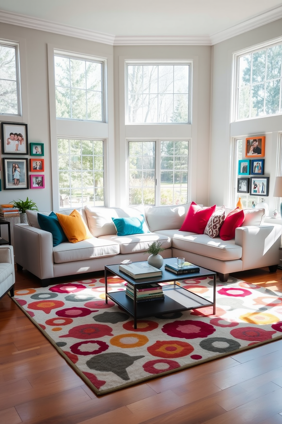 A cozy white sectional sofa is positioned in the center of a bright family room, surrounded by vibrant throw pillows in various colors. A large area rug with a playful pattern anchors the seating area, complementing the warm wooden floors and natural light streaming in through oversized windows. The walls are adorned with family photos in colorful frames, creating a personal and inviting atmosphere. A stylish coffee table sits in front of the sectional, adorned with decorative books and a small plant for a touch of greenery.