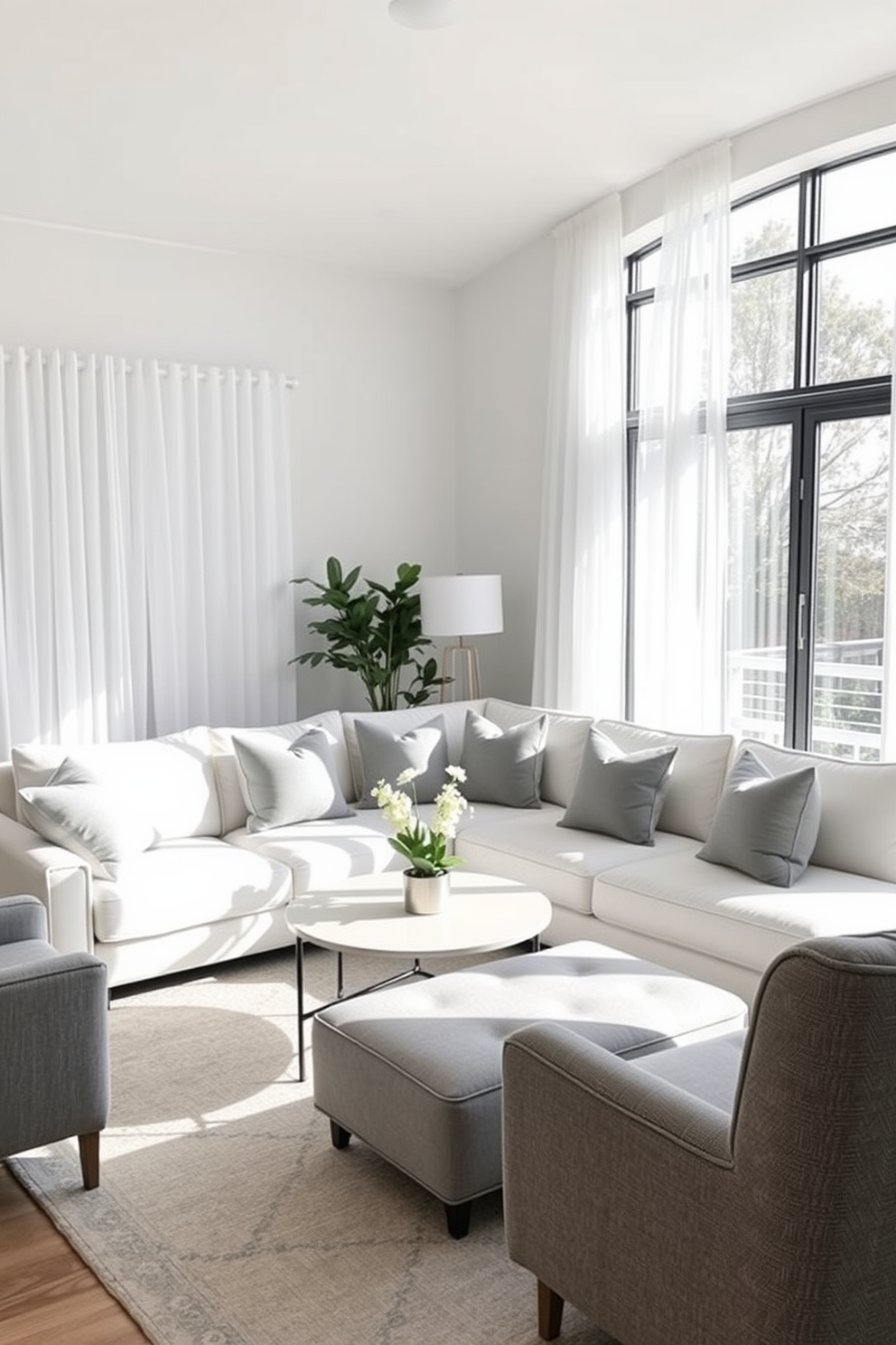 A serene family room with a soft gray and white color palette. The space features a plush white sectional sofa adorned with gray throw pillows and a light gray area rug underneath. Natural light floods the room through large windows dressed in sheer white curtains. A modern coffee table sits in the center, complemented by a cozy gray armchair in the corner.