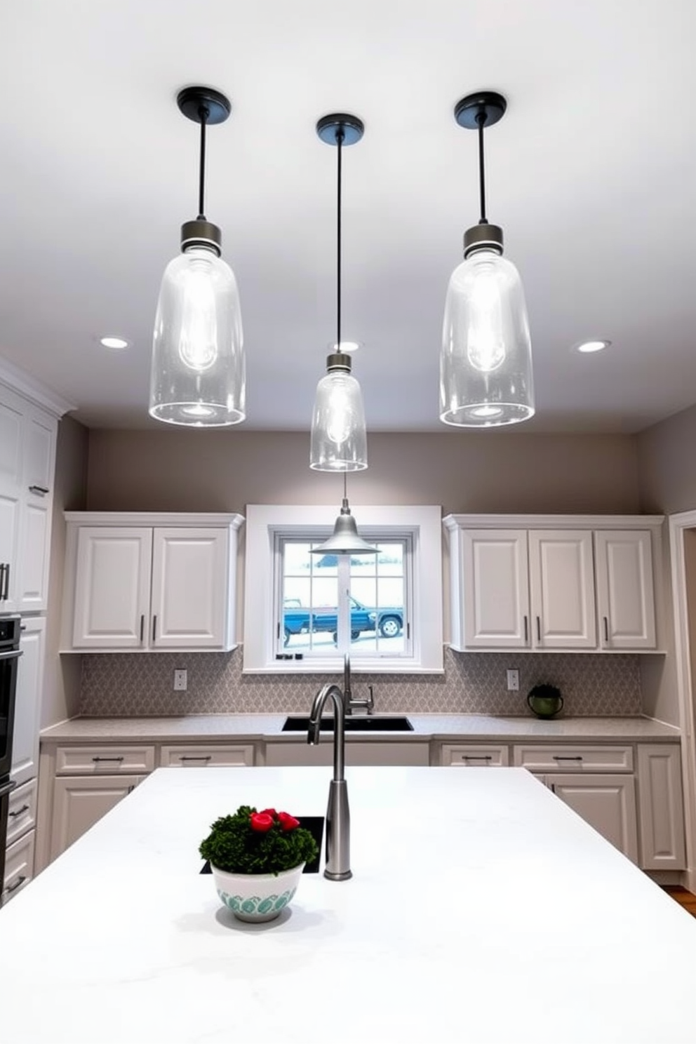 A bright and inviting kitchen featuring layered lighting that enhances both ambiance and functionality. Recessed ceiling lights provide overall illumination while pendant lights above the island create a focal point. The kitchen showcases a combination of white cabinetry and a sleek white quartz countertop. A large farmhouse sink is centered beneath a window, with a stylish backsplash adding texture and interest.