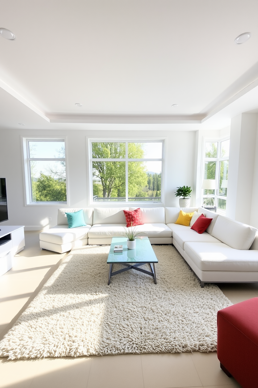 A bright white ceiling features recessed lighting that creates a warm and inviting atmosphere. The living room is designed with a minimalist approach, showcasing a large white sectional sofa adorned with colorful throw pillows. Large windows allow natural light to flood the space, enhancing the airy feel of the room. A sleek coffee table sits in the center, surrounded by a plush area rug that adds texture and comfort.