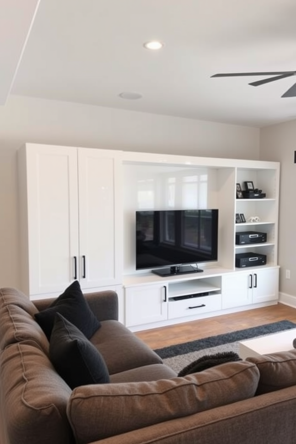 A sleek white entertainment center is the focal point of the man cave, featuring clean lines and ample storage for media devices. The space is accented with a plush sectional sofa in a deep gray, creating a cozy atmosphere for relaxation and entertainment.