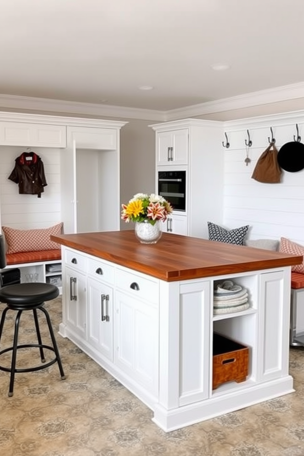 A functional island for extra workspace features a large wooden surface with ample storage underneath. It is surrounded by stylish bar stools and integrated appliances, creating a seamless flow in the kitchen. White mudroom design ideas include built-in benches with storage cubbies and hooks for coats. The walls are adorned with shiplap, and the floor is covered with durable, patterned tiles for easy maintenance.