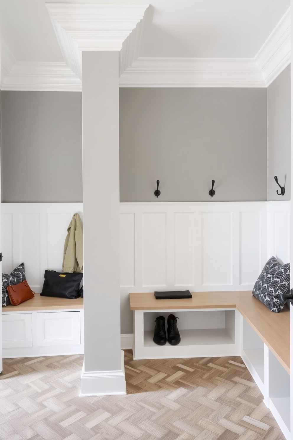 Elegant crown molding for a finished look. The mudroom features built-in benches with storage underneath and hooks for hanging coats and bags. The walls are painted in a soft gray color, complementing the white crown molding. A durable tile floor in a herringbone pattern adds texture and style to the space.