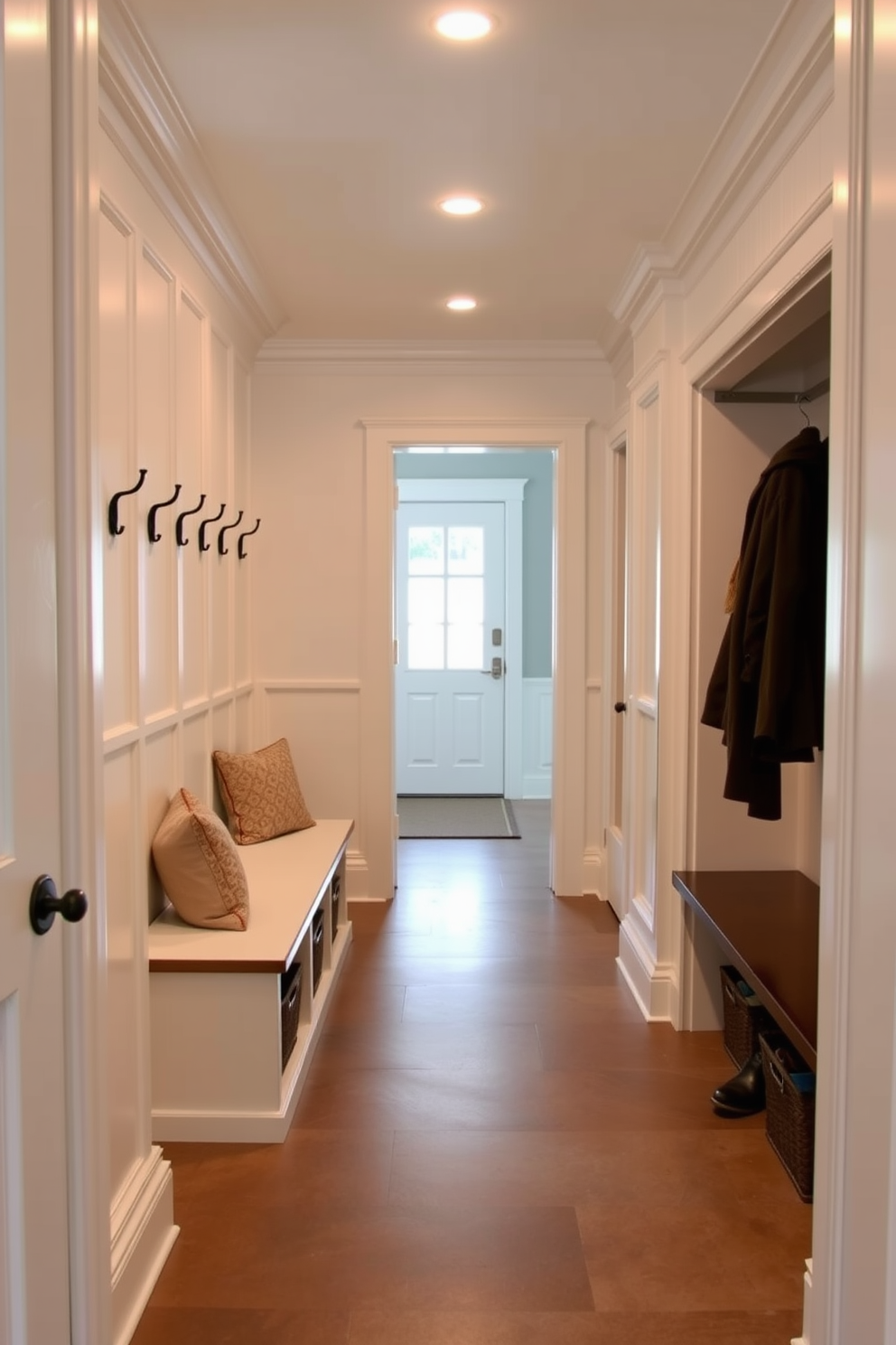 Classic wainscoting lines the walls of a spacious mudroom, creating an elegant and timeless atmosphere. The floor is adorned with a durable yet stylish tile that complements the wainscoting, while a built-in bench with plush cushions invites comfort. The mudroom features a combination of open and closed storage, with neatly arranged hooks for coats and baskets for shoes. Soft lighting illuminates the space, highlighting the classic design elements and providing a welcoming entry point to the home.