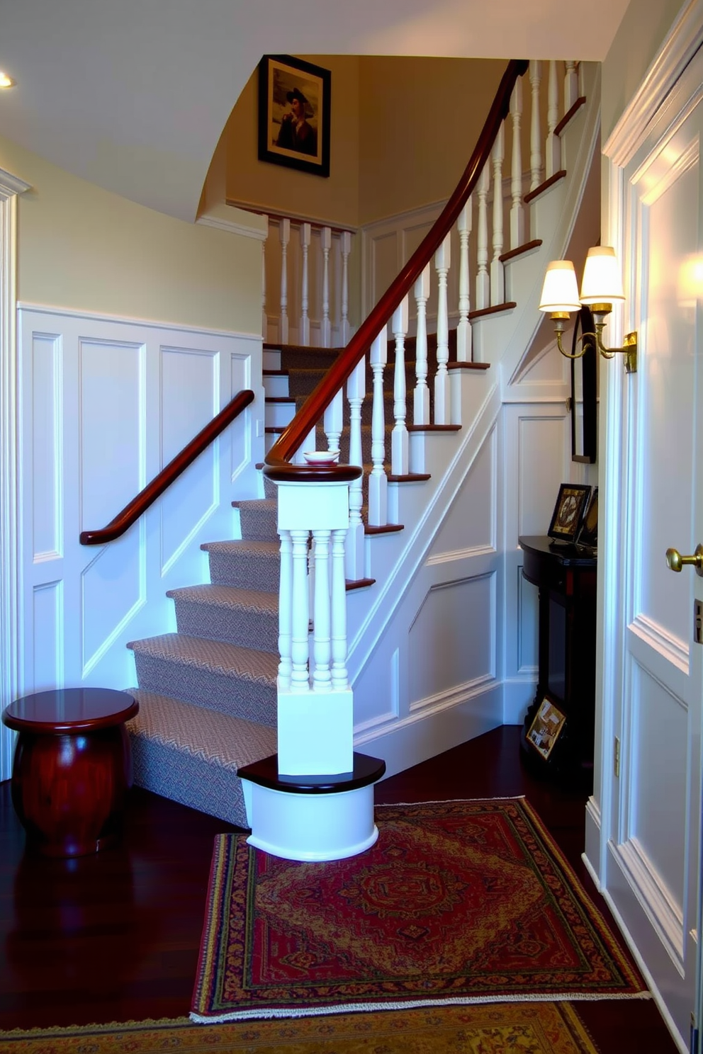 A traditional white staircase features elegant wainscoting along the walls, enhancing the classic aesthetic of the space. The staircase is adorned with a polished wooden handrail that complements the white balusters, creating a timeless look. At the base of the staircase, a beautifully woven area rug adds warmth and texture to the entryway. Soft, ambient lighting illuminates the staircase, highlighting the intricate details of the wainscoting and inviting guests to ascend.