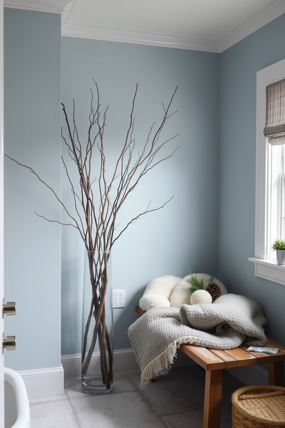 A serene winter bathroom setting infused with natural elements. Branches and twigs are artistically arranged in a tall vase, adding a touch of nature to the space. The walls are painted in a soft, cool blue hue reminiscent of winter skies. A cozy wooden bench is placed near the window, adorned with plush blankets and seasonal decor.