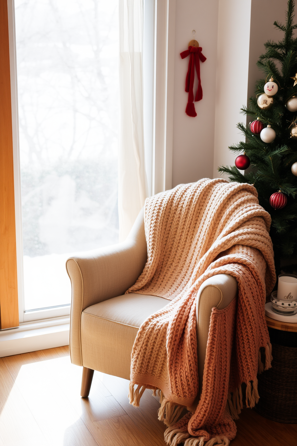 A cozy chair is positioned in a well-lit corner of the room, draped with a soft knitted throw in warm colors. The surrounding area is adorned with seasonal decorations, including a small pine tree and festive ornaments that evoke a sense of winter comfort.