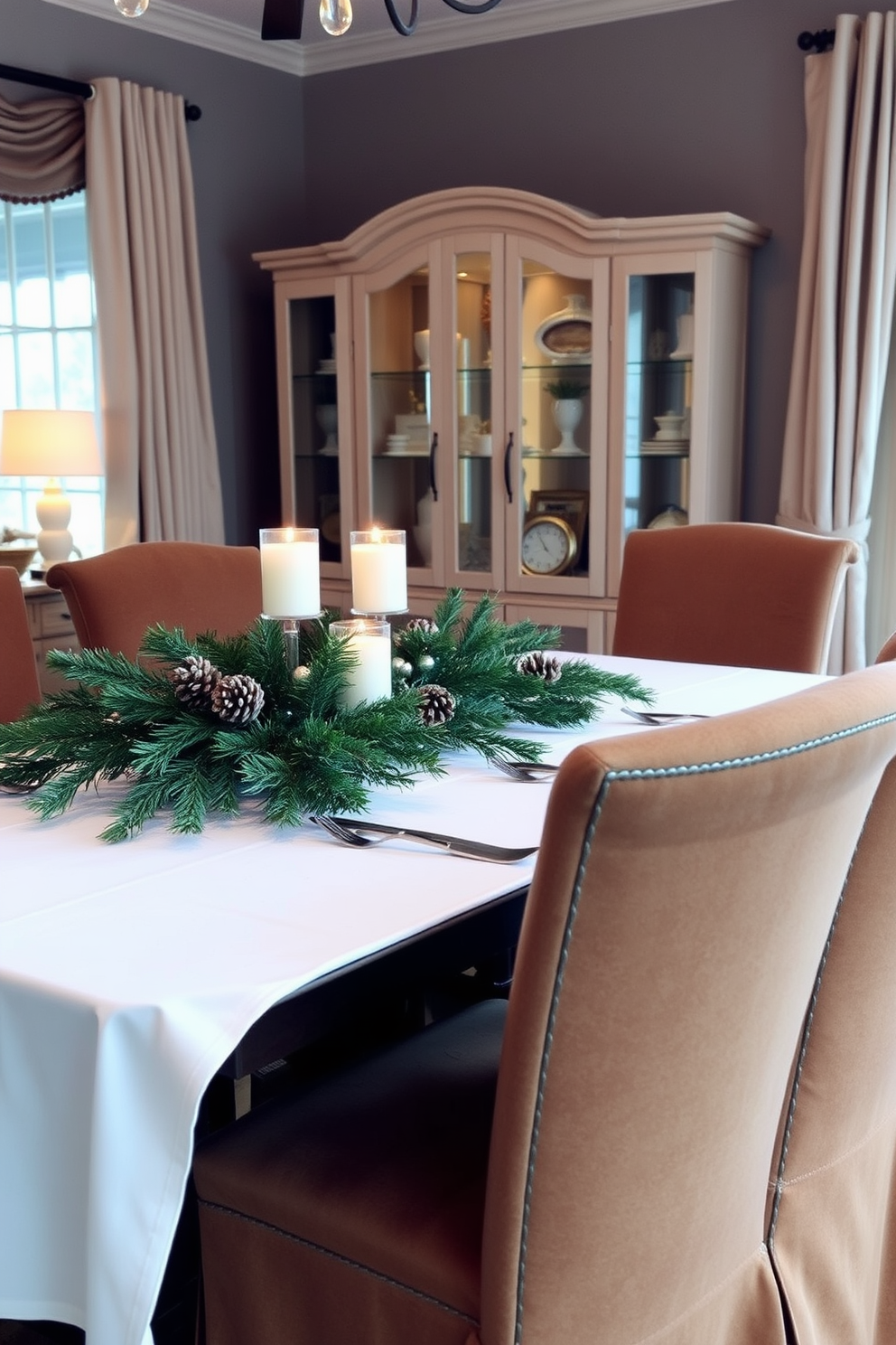 A cozy winter dining room setting. The table is adorned with a white tablecloth and a centerpiece of evergreen branches with pinecones and seasonal candles. Soft, warm lighting creates an inviting atmosphere. Surrounding the table are upholstered chairs in rich, deep colors that complement the winter theme.