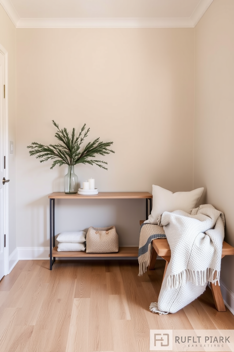 A serene winter entryway features a neutral color palette that promotes a calm atmosphere. The walls are painted in soft beige, while the floor showcases light oak wood, creating a warm and inviting space. A stylish console table is adorned with a simple arrangement of pine branches and white candles. Cozy woolen throw blankets are draped over a nearby bench, inviting guests to relax as they enter.