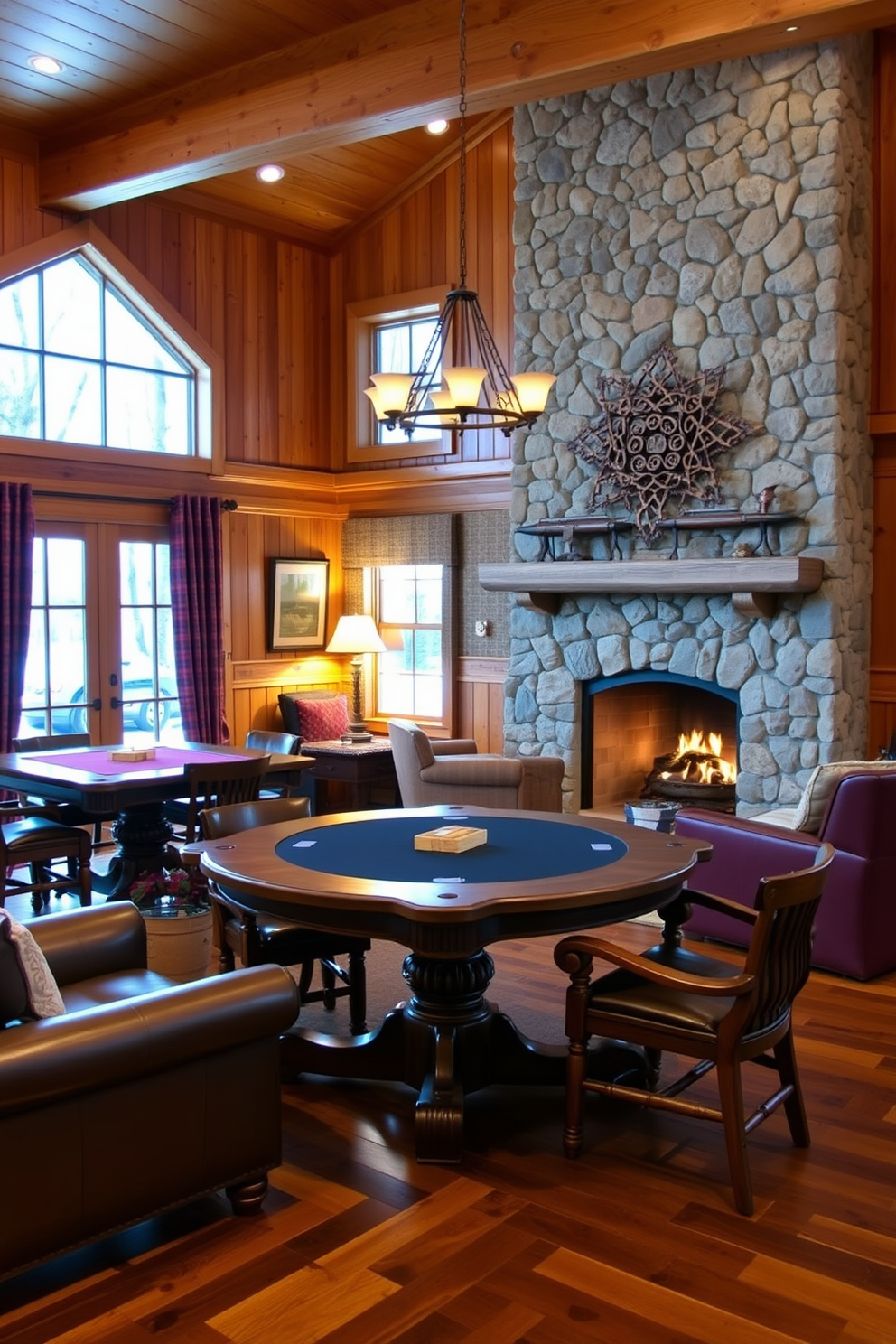 A cozy winter game room features rustic wooden game tables surrounded by comfortable seating. The walls are adorned with warm-toned wood paneling, and a large stone fireplace adds a welcoming glow to the space.