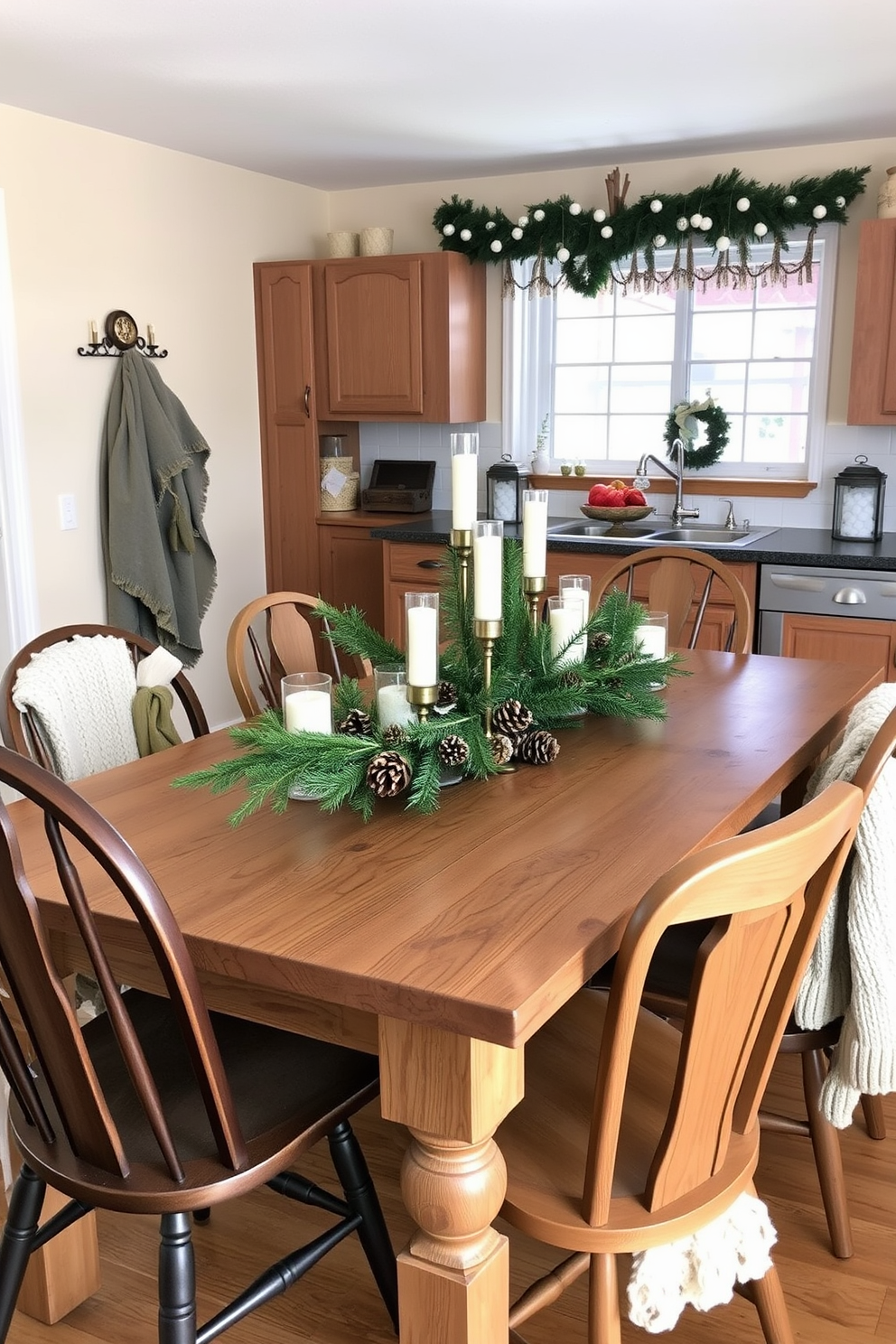 A cozy winter kitchen setting with a rustic wooden dining table at the center. The table is adorned with a stunning winter-themed centerpiece featuring a mix of evergreen branches, pinecones, and white candles in glass holders. Surrounding the table are mismatched wooden chairs, each draped with soft, knitted throws. The kitchen walls are painted in a warm cream color, and a festive garland is hung above the window, adding to the cheerful atmosphere.