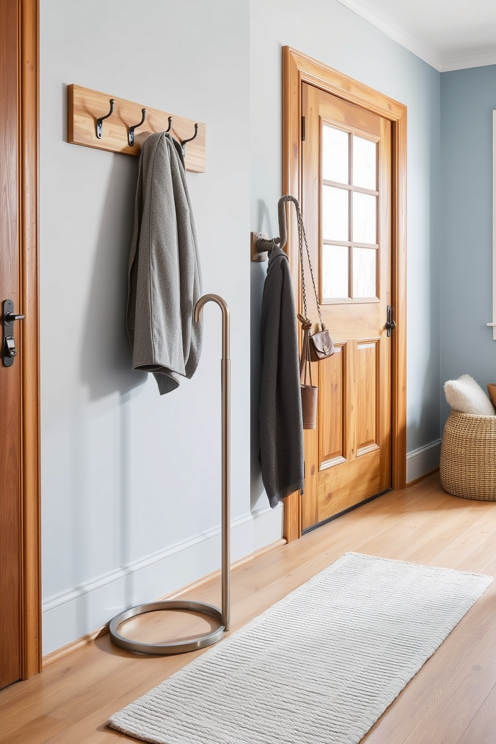 A chic umbrella stand is elegantly positioned in the corner of a cozy winter mudroom. The stand is crafted from brushed metal, featuring a sleek design that complements the warm wooden accents of the space. Beneath the umbrella stand, a textured rug in soft gray adds warmth and comfort to the floor. The walls are adorned with hooks for coats, painted in a soft blue that evokes a serene winter atmosphere.