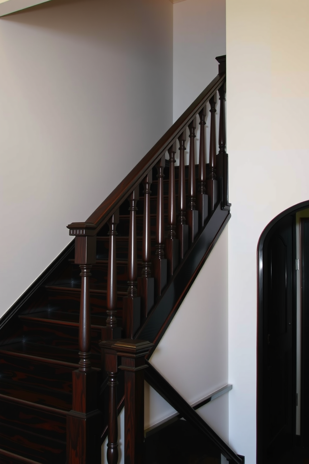 A dark stained wood staircase ascends gracefully against light-colored walls creating a striking contrast. The staircase features elegant balusters and a polished handrail that enhances the inviting atmosphere of the space.