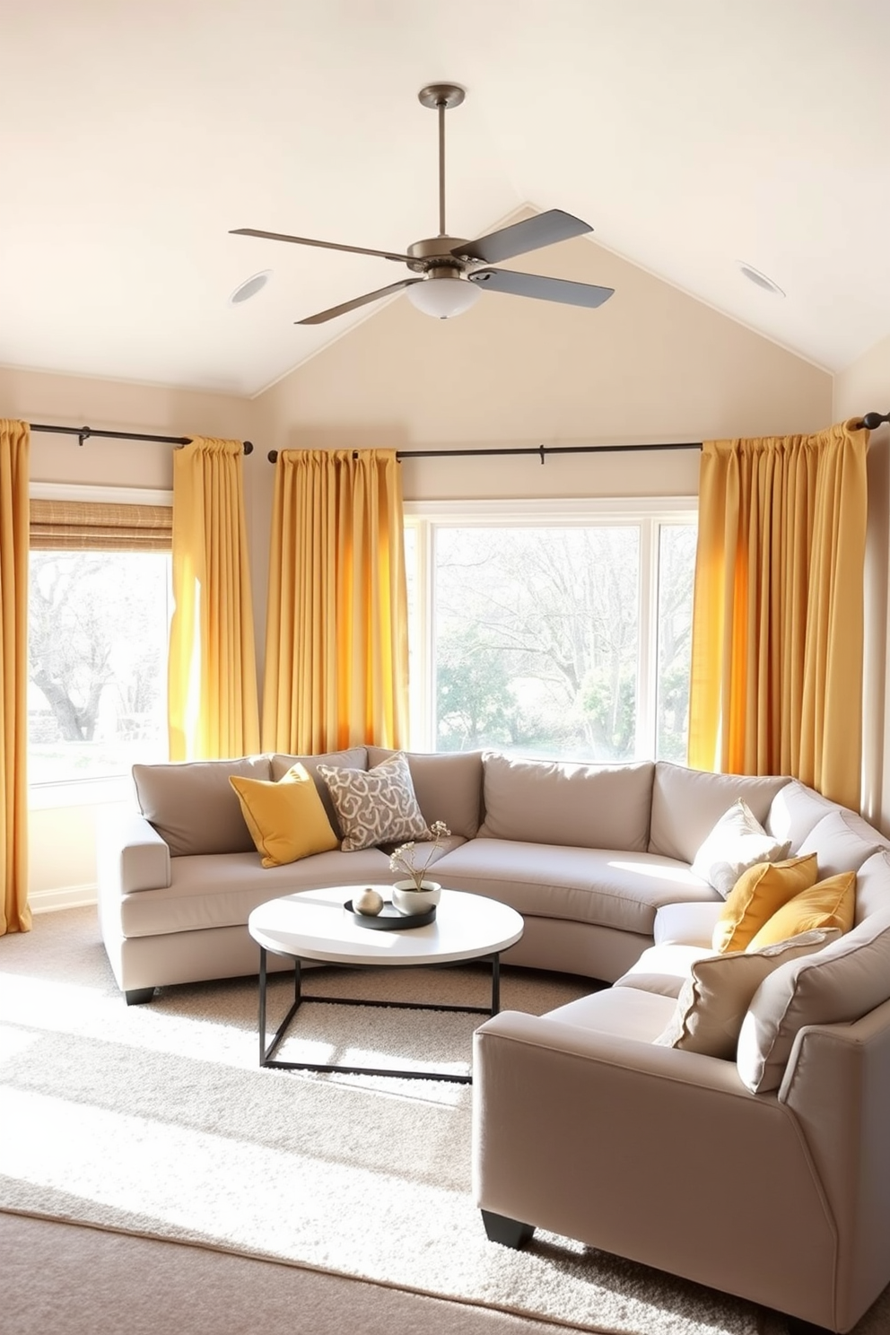 A cozy family room filled with natural light. The walls are painted in a soft beige, complementing the muted yellow curtains that frame the large windows, allowing gentle sunlight to filter through. A plush sectional sofa in a light gray hue is arranged around a modern coffee table. Decorative throw pillows in various shades of yellow and gray add warmth and texture to the seating area.