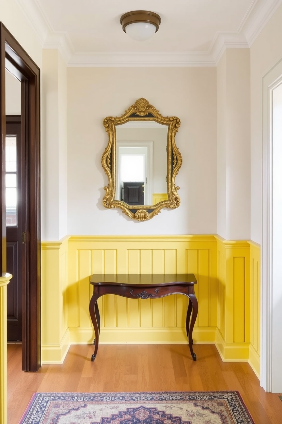 A bright and inviting foyer features yellow wainscoting that adds a touch of classic elegance to the space. The walls above are painted in a soft cream color, creating a warm contrast with the cheerful yellow below. The foyer is adorned with a vintage console table made of dark wood, topped with a decorative mirror in an ornate gold frame. A stylish area rug in neutral tones lies beneath, enhancing the overall charm and sophistication of the entrance.