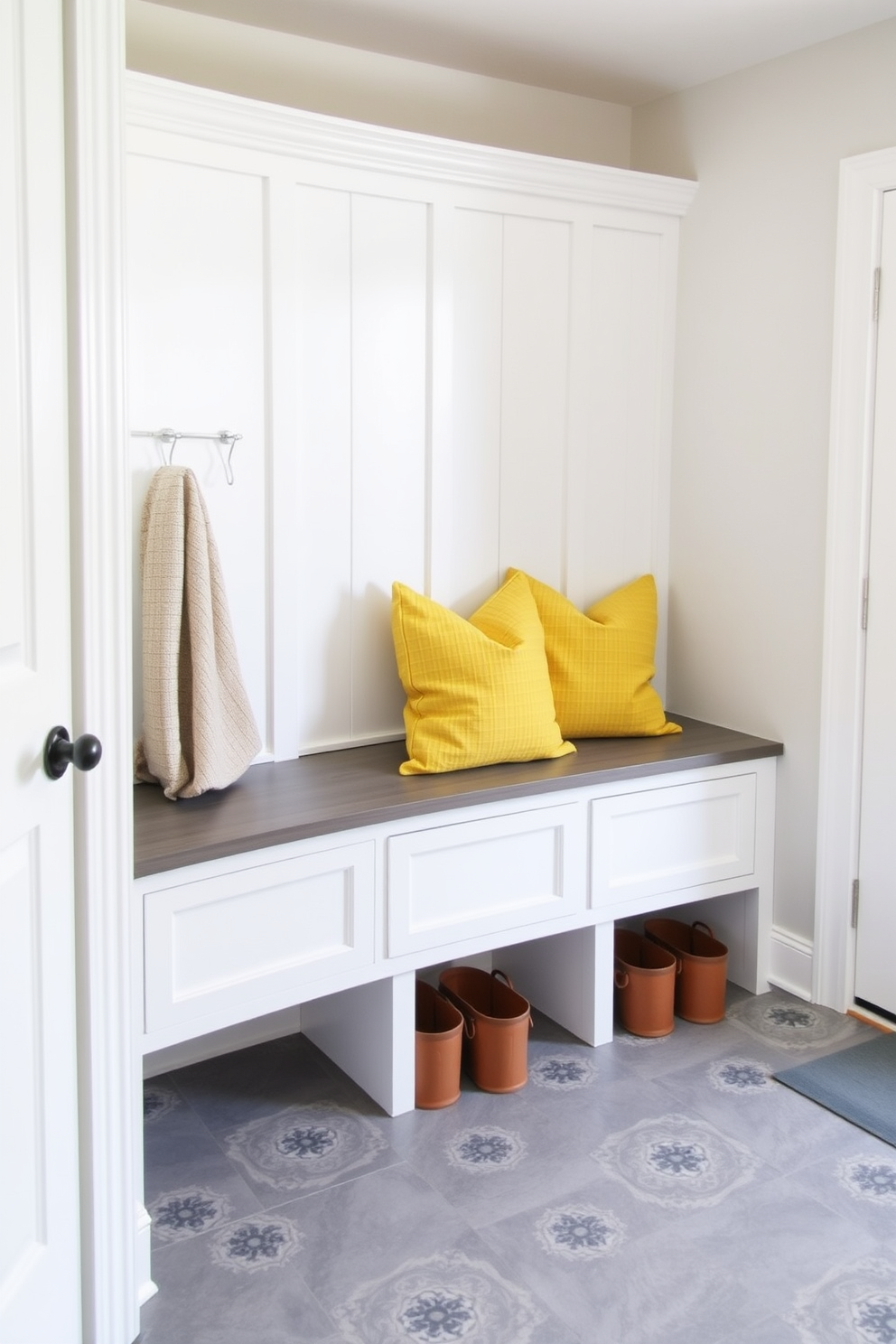 A cozy mudroom featuring yellow accent pillows for added comfort. The walls are painted a soft white, and the flooring consists of durable gray tile.